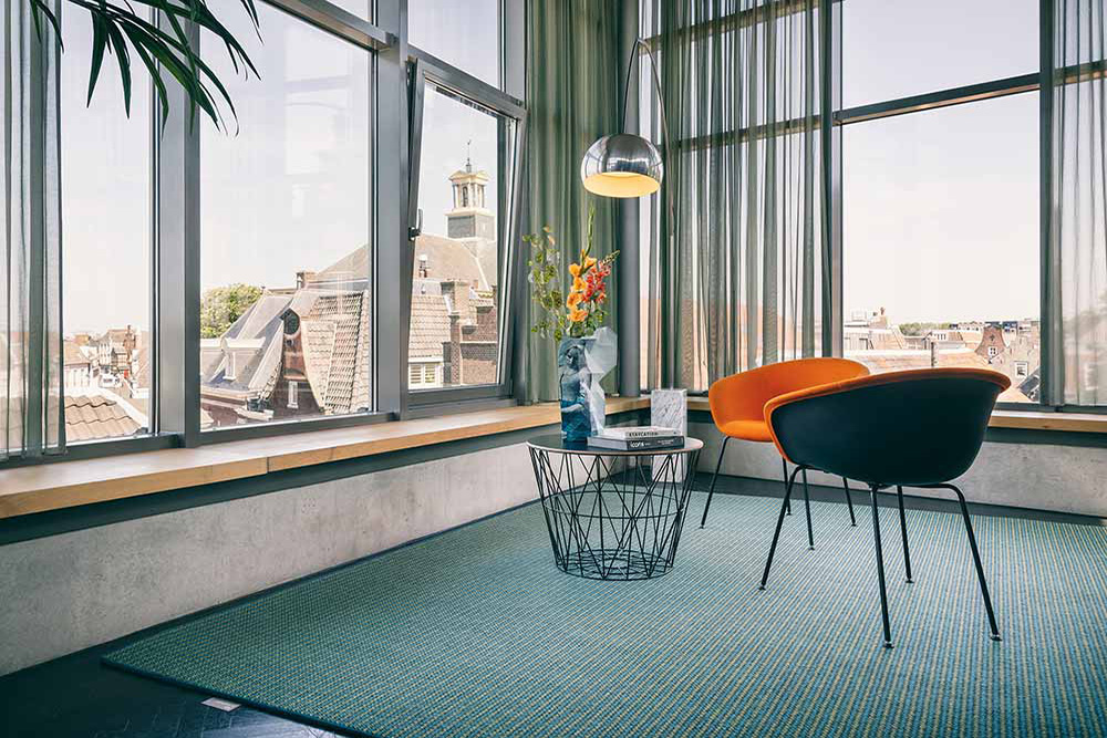 orange chairs & teal colored rug in sitting room