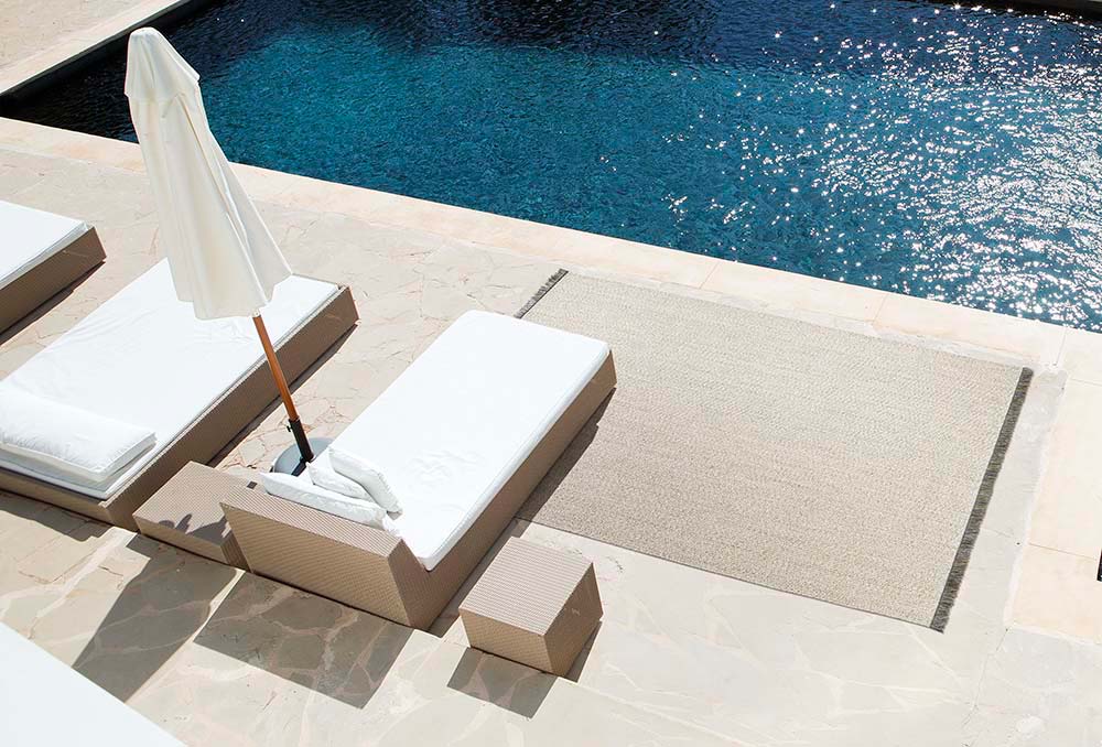 limited edition poolside vinyl rug under chaise loungers next to pool
