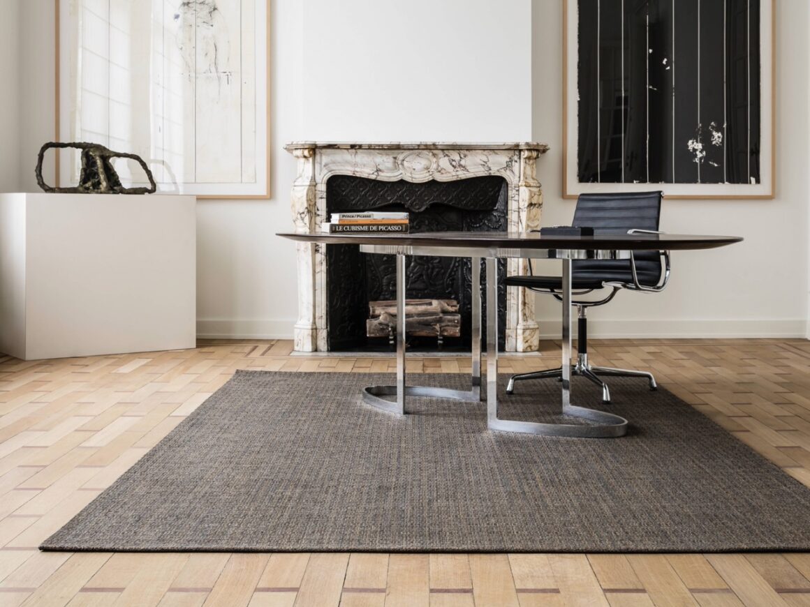 dark area rug on light wood floor in an office