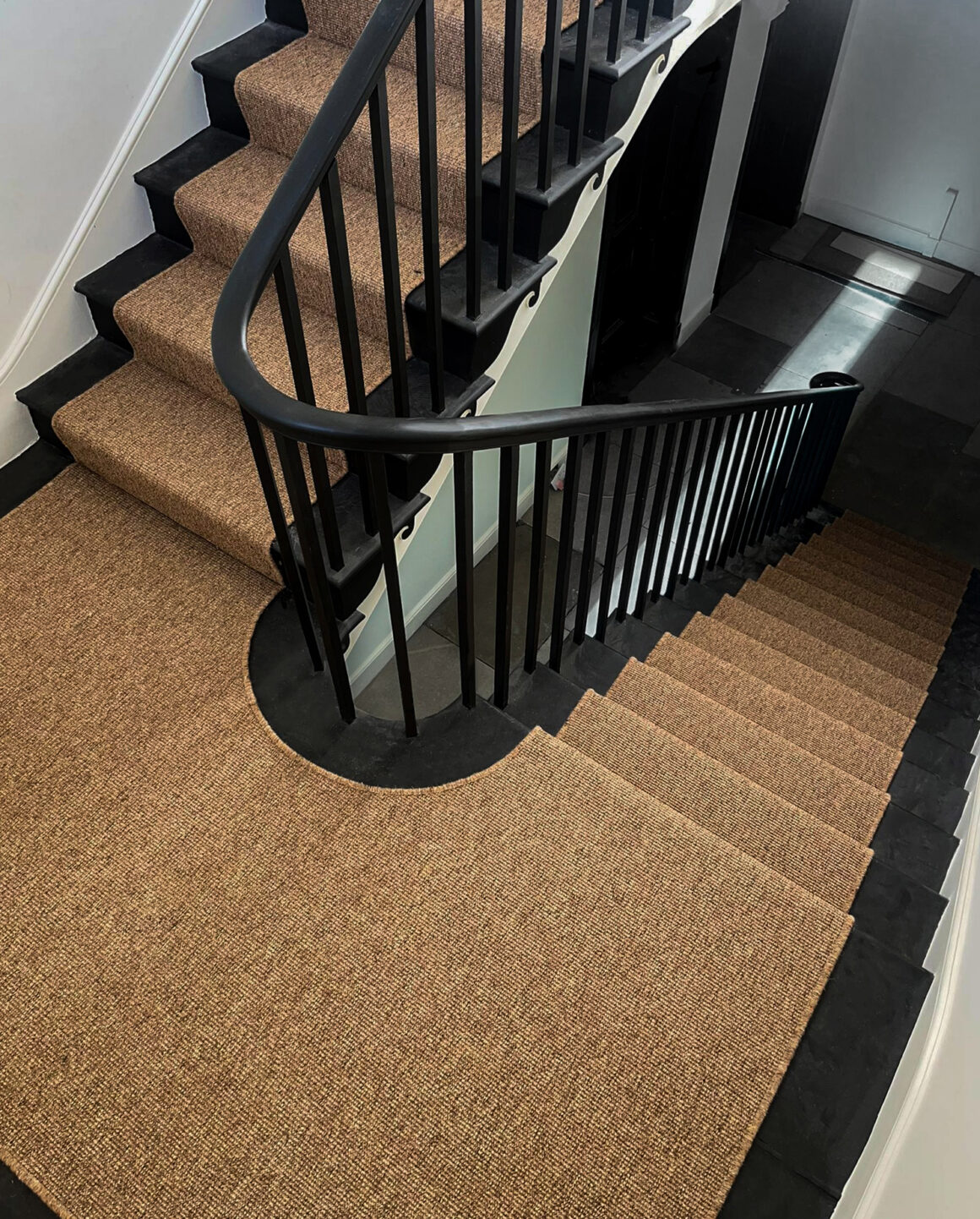 synthetic sisal stair runner in warm color on black floor