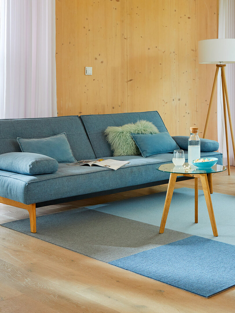 blue couch with a tonal blue rug